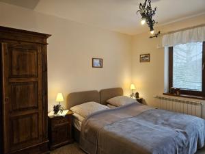 a bedroom with a bed and a dresser and a window at Willa Litworówka in Biały Dunajec