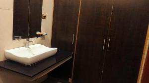 a bathroom with a white sink and a mirror at Royalz Hotel in Lahore