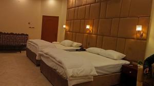 a hotel room with two beds in a room at Royalz Hotel in Lahore