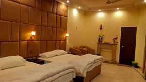 a hotel room with two beds and a fireplace at Royalz Hotel in Lahore