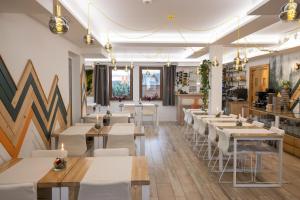 a restaurant with white tables and white chairs at Willa Pod Termą - pokoje pod stokiem Kotelnica i przy Termie Bania in Białka Tatrzańska