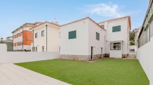 an exterior view of a house with a green lawn at Póvoa Studios by Pomerania in Póvoa de Varzim +83 photos