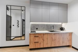 a kitchen with white cabinets and a sink at Podmurna Zakątek in Toruń