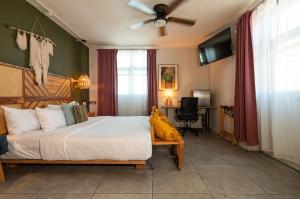 a bedroom with a large bed and a desk at Selina Oaxaca in Oaxaca City