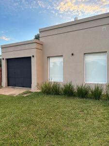 a house with two garage doors and a grass yard at Nuestro Lugar Soñado in Concepción del Uruguay