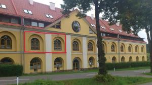 a large yellow building with a clock on it at Ferienwohnung Alexanderhof in Sankt Lambrecht