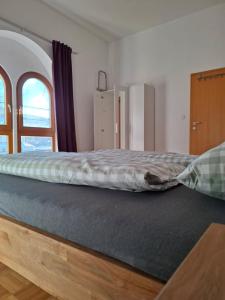 a large bed in a room with a window at Ferienwohnung Alexanderhof in Sankt Lambrecht