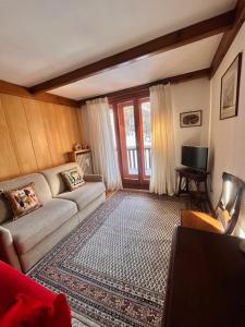 a living room with a couch and a tv at La casa di Marta, charme e relax in Breuil-Cervinia