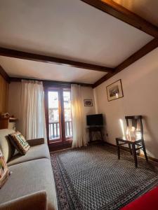 a living room with a couch and a window at La casa di Marta, charme e relax in Breuil-Cervinia