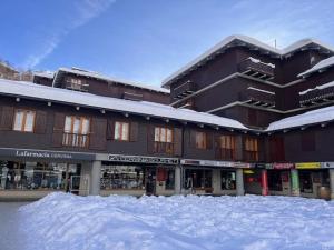 a snow covered parking lot in front of a building at La casa di Marta, charme e relax in Breuil-Cervinia