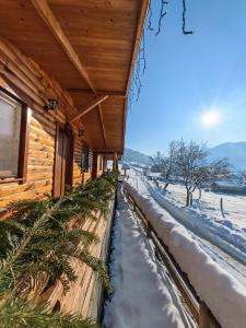a log cabin in the snow with a fence at Casuțele de sub deal in Vişeu de Sus +51 photos