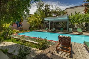 a swimming pool with a chair next to a house at Villa dos Graffitis Pousada in Morro de São Paulo