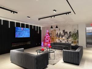 a living room with couches and a christmas tree at Nova Hotel Brooklyn in Brooklyn