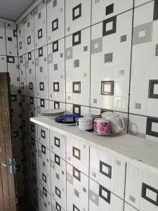 a white tiled wall with cups and plates on a counter at Beira Mar in Tramandaí +25 photos