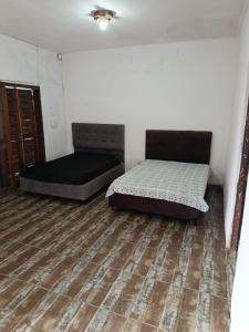 two beds in a room with a wooden floor at Beira Mar in Tramandaí