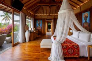a bedroom with a bed with a mosquito net at Kappa Senses Zanzibar in Pwani Mchangani +32 photos