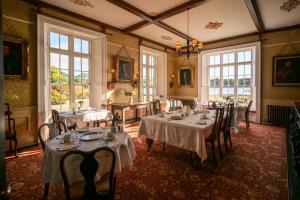 a dining room with tables and chairs and windows at The Castle in Castlehaven