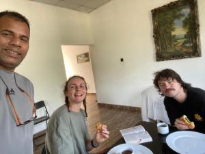 two men and a woman sitting at a table eating food at A&B Events Guest in Matale