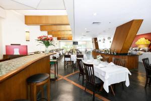 a restaurant with tables and chairs and a bar at Flat em Perdizes, perto da PUC e Allianz Parque in São Paulo