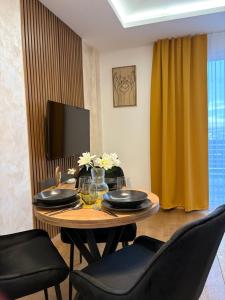 a dining room with a table with chairs and a television at Skyline Panorama in Vrnjačka Banja