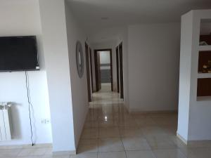 a hallway with a flat screen tv on a wall at Appartements Mimosa in Tefeschoun