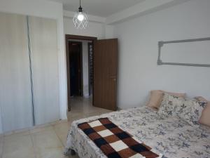 a bedroom with a bed and a chandelier at Appartements Mimosa in Tefeschoun