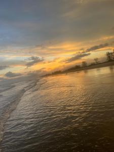 a sunset over a body of water with a beach at Casa ilha comprida perto da praia in Ilha Comprida