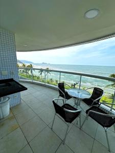 a balcony with a table and chairs and the ocean at Apt com vista para o mar e churrasqueira in Guaratuba +13 photos