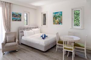 a bedroom with a bed and a table and chairs at Lustica-Marina GOLD APARTMAN in Radovici