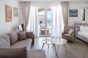 a living room with a couch and a table at Lustica-Marina GOLD APARTMAN in Radovici