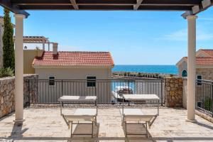 a patio with chairs and a view of the ocean at Lustica-Marina GOLD APARTMAN in Radovici