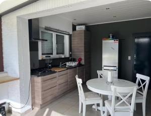 a kitchen with a white table and chairs and a refrigerator at Dar Fouad in Vilvoorde