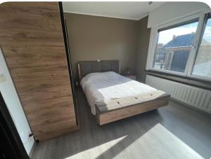 a bedroom with a bed and a large wooden door at Dar Fouad in Vilvoorde
