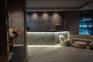 a hotel lobby with a chair and a reception desk at Adrett Hotel Königsallee in Düsseldorf +36 photos