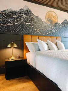 a bedroom with a bed with a painting on the wall at The Florentine Waterfront Hotel in Florence