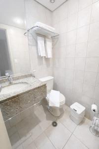a white bathroom with a toilet and a sink at Flat em Perdizes, perto da PUC e Allianz Parque in São Paulo +8 photos