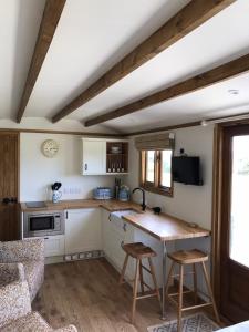 a kitchen with a table and chairs in a room at Ty Beti at Gorlan yr Efail Shepherds Hut with Private Hot Tub in Holyhead +48 photos