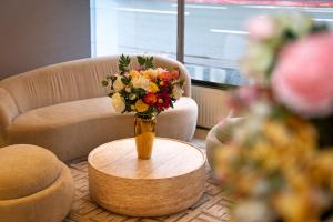 a vase of flowers sitting on a table in a room at Adrett Hotel Königsallee in Düsseldorf
