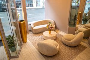 a room with chairs and a table with a vase of flowers at Adrett Hotel Königsallee in Düsseldorf