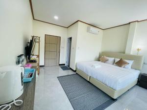 a bedroom with a bed and a television in it at Libong River View in Ban Maphrao (2) +9 photos