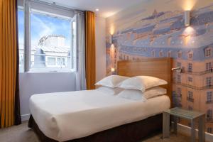 a bedroom with a large bed with a large window at Hôtel Albe Saint Michel in Paris