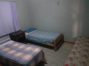 a bedroom with two twin beds and a rug at Latido de Montaña in Bialet Massé