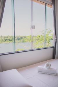 a bed with a towel on it in front of a window at Pousada Barreirinhas in Barreirinhas +35 photos