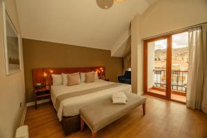 a bedroom with a large bed and a large window at Saska Boutique Hotel in Cusco