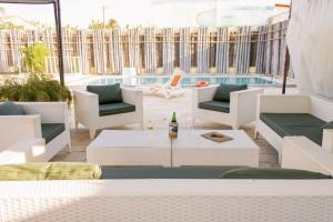 a patio with white furniture and a bottle of beer at Pousada Barreirinhas in Barreirinhas