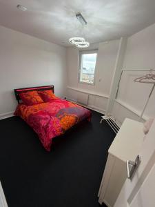 a bedroom with a red bed and a window at Petit appartement charmant in Lille