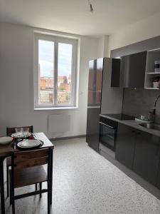 a kitchen with a table and a tableasteryasteryasteryasteryasteryasteryasteryastery at Petit appartement charmant in Lille +10 photos