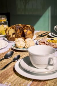 a table with a cup of coffee and a loaf of bread at Pousada Barreirinhas in Barreirinhas