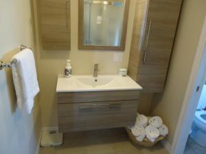 een badkamer met een wastafel, een spiegel en handdoeken bij Domaine sur une plage in Saint-Félicien