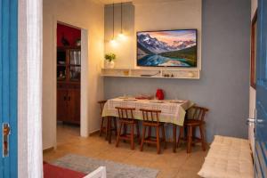 a kitchen with a table with chairs and a painting on the wall at Costa Family-Little house in the center in Santa Rita do Sapucaí